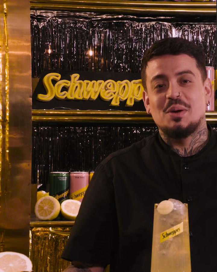 Bartender presenting a Schweppes highball in the campaign set