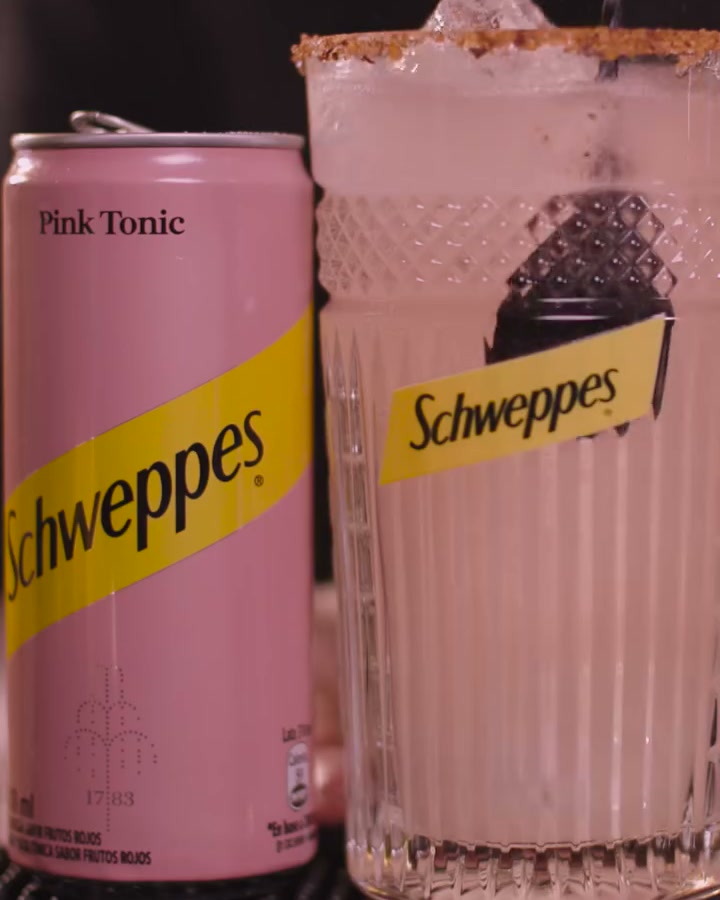 Schweppes Pink Tonic can beside its finished cocktail